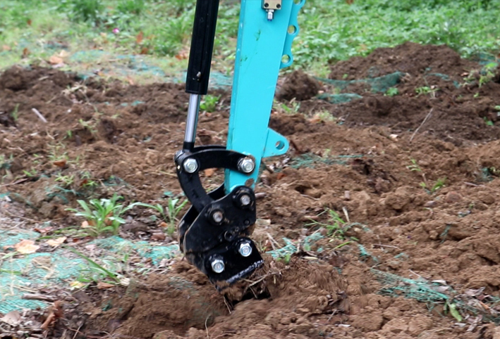 Installing a scarifier on a small excavator during soil loosening operation